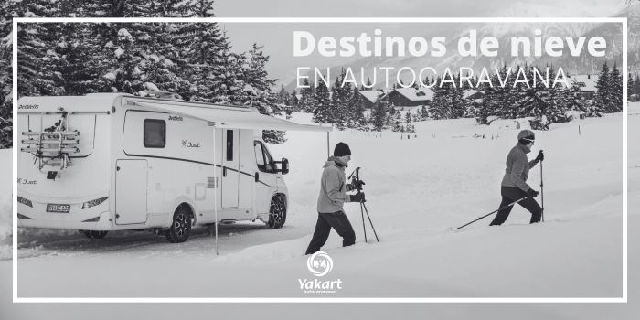 Autocaravana Dethleffs con dos esquiadores en una montaña con nieve